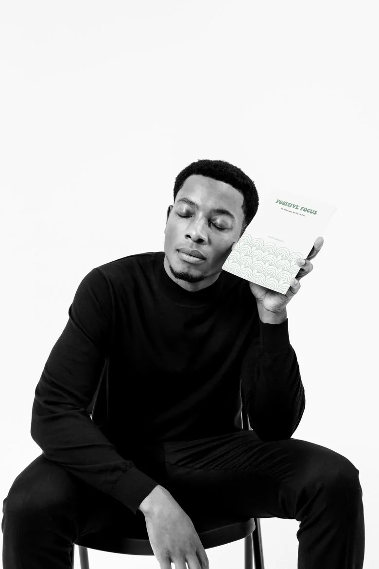 Samy holding his book, Positive Focus